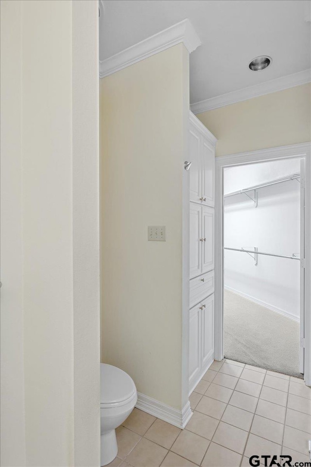 bathroom featuring toilet, tile patterned flooring, and crown molding