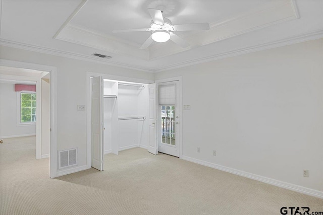 spare room featuring ceiling fan, light colored carpet, and a tray ceiling