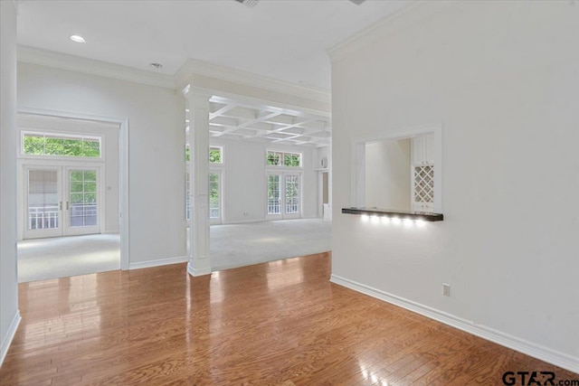 spare room with a healthy amount of sunlight, light hardwood / wood-style flooring, and french doors