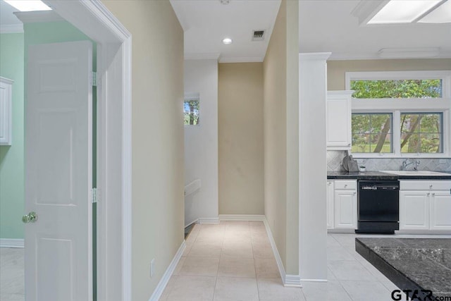 hallway with sink, crown molding, and light tile patterned floors