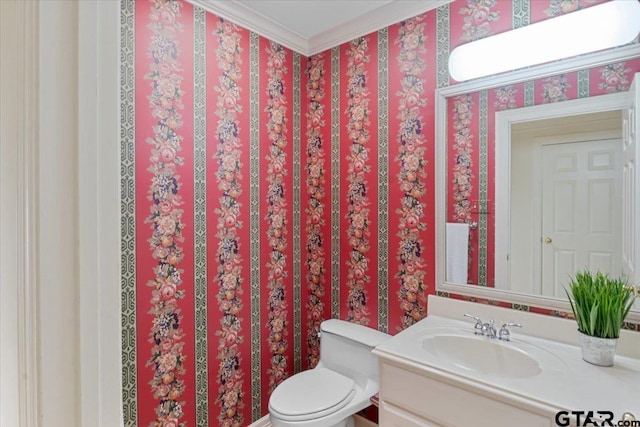 bathroom with ornamental molding, vanity, and toilet