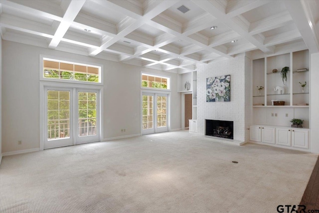 unfurnished living room featuring beam ceiling, a fireplace, coffered ceiling, built in features, and french doors