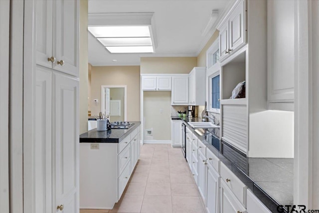 kitchen with light tile patterned flooring, stainless steel gas cooktop, white cabinetry, and sink