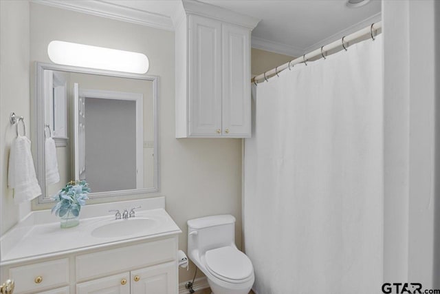 bathroom with toilet, vanity, and ornamental molding