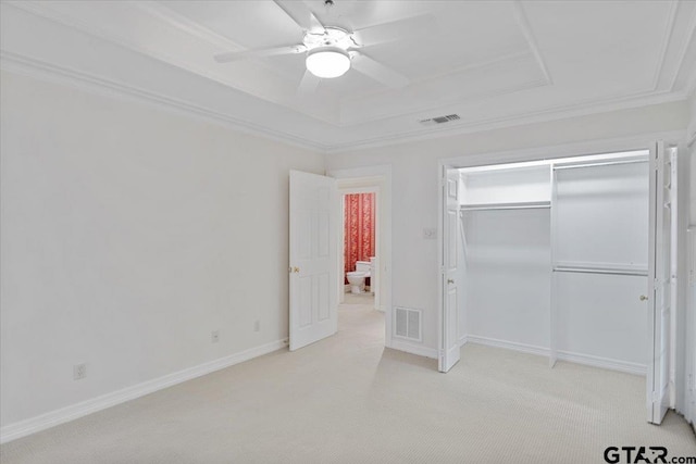 unfurnished bedroom featuring ceiling fan, a closet, crown molding, and light colored carpet