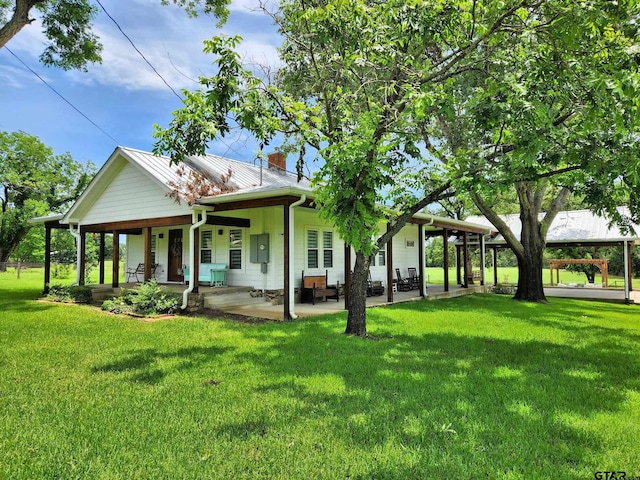 back of property with a lawn and covered porch