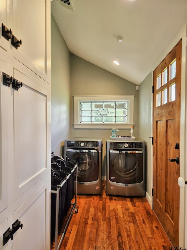 washroom with washing machine and dryer and wood-type flooring