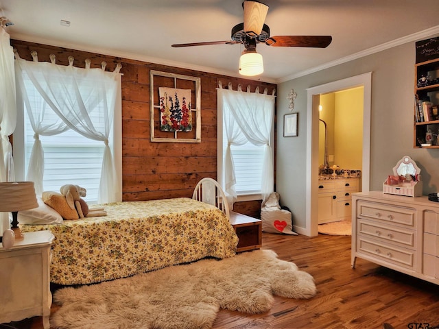 bedroom with hardwood / wood-style flooring, ensuite bath, ceiling fan, crown molding, and wooden walls