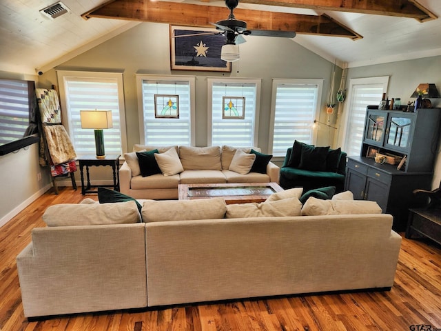 living room with light wood-type flooring and vaulted ceiling with beams