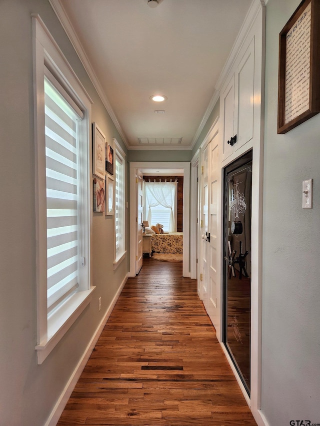 hallway featuring ornamental molding and dark hardwood / wood-style floors