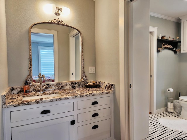 bathroom with toilet, vanity, tile patterned floors, and crown molding