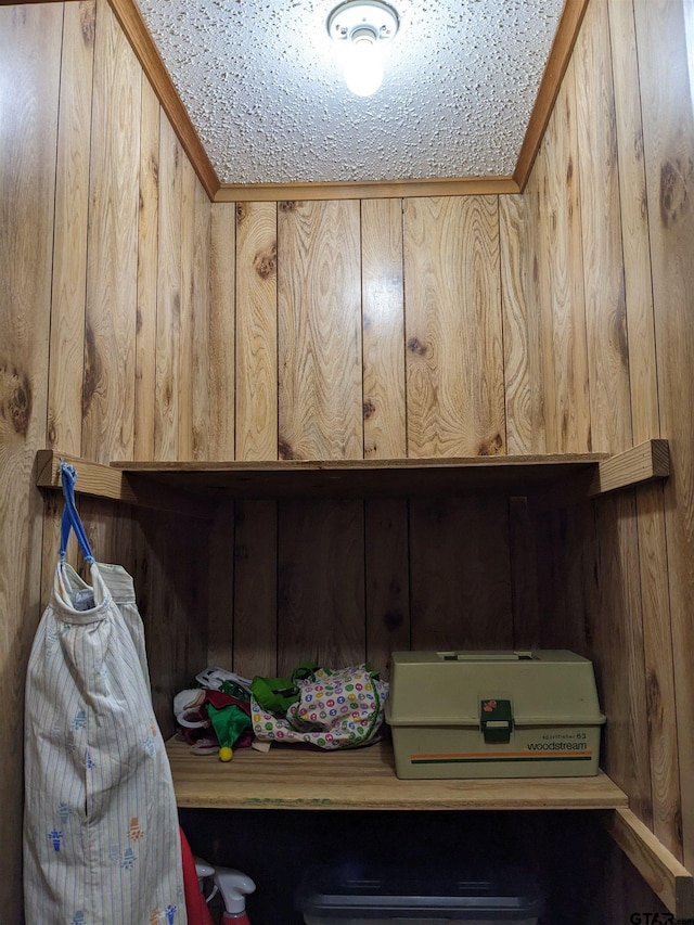 laundry room with wood walls