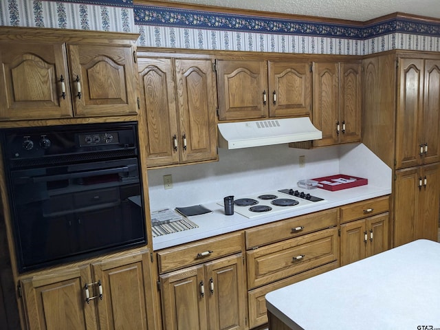 kitchen featuring black oven, white stovetop, and a textured ceiling