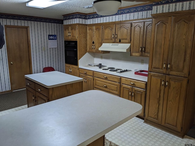 kitchen with black oven, a textured ceiling, a kitchen island, and white cooktop