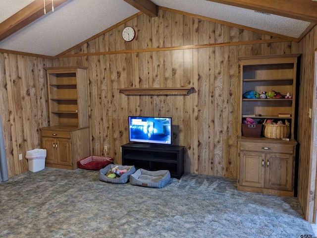 living room with a textured ceiling, carpet, wood walls, and vaulted ceiling with beams