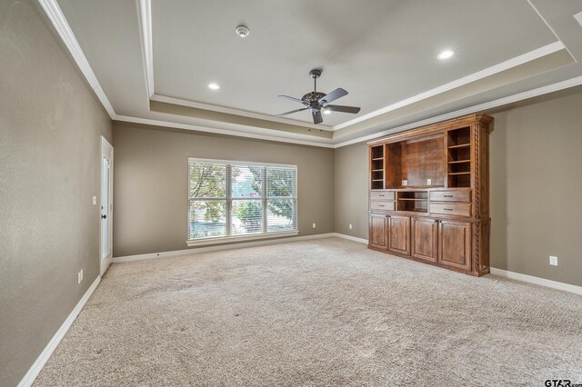 2441 Fm 2685, Gilmer, TX 75644 - unfurnished living room with a raised ceiling, ceiling fan, crown molding, light colored carpet, and baseboards