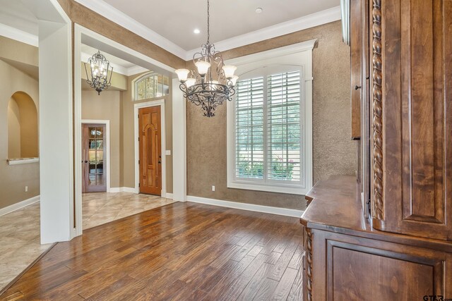 2441 Fm 2685, Gilmer, TX 75644 - unfurnished dining area featuring a chandelier, wood finished floors, ornamental molding, and baseboards