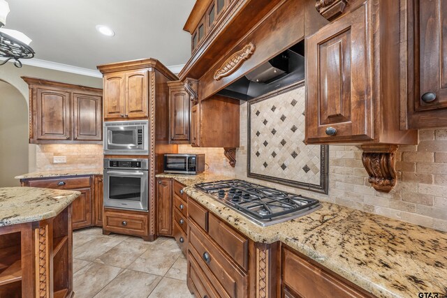 2441 Fm 2685, Gilmer, TX 75644 - kitchen with stainless steel appliances, tasteful backsplash, light stone countertops, crown molding, and light tile patterned floors