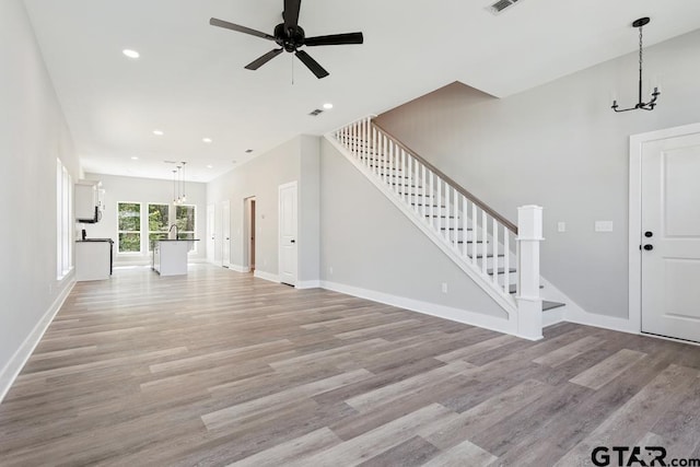 16330 Crossing Cir, Lindale, TX 75771 - unfurnished living room with a chandelier, stairway, light wood-type flooring, recessed lighting, and a ceiling fan