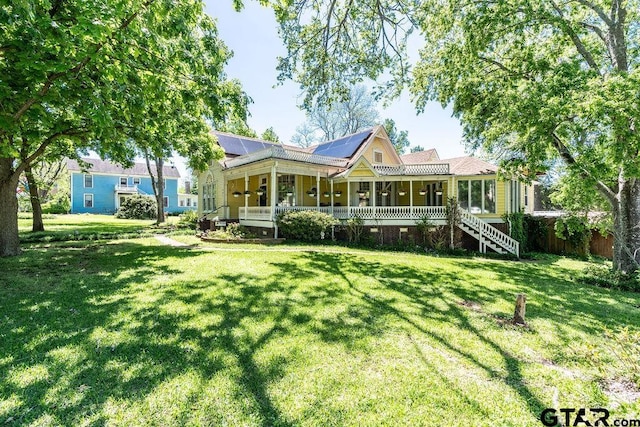 rear view of property with a porch and a yard