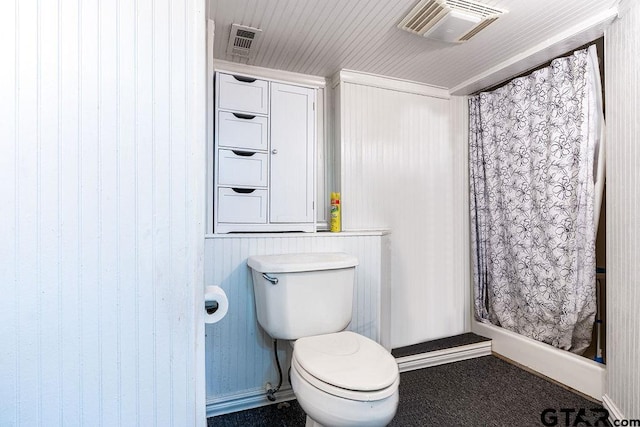 bathroom featuring wood walls and toilet