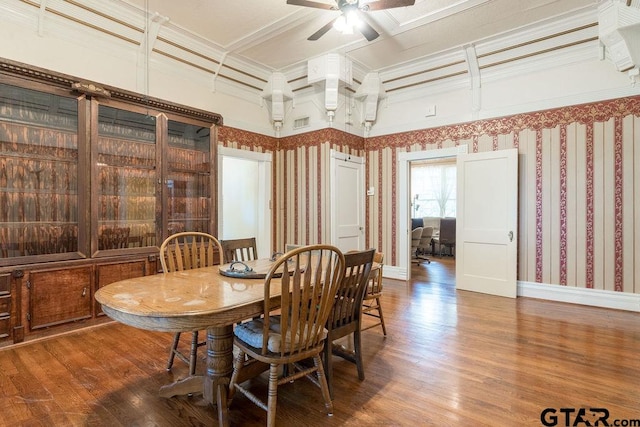 dining room featuring dark hardwood / wood-style flooring, ceiling fan, and crown molding