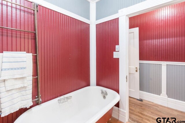 bathroom featuring hardwood / wood-style flooring and a washtub