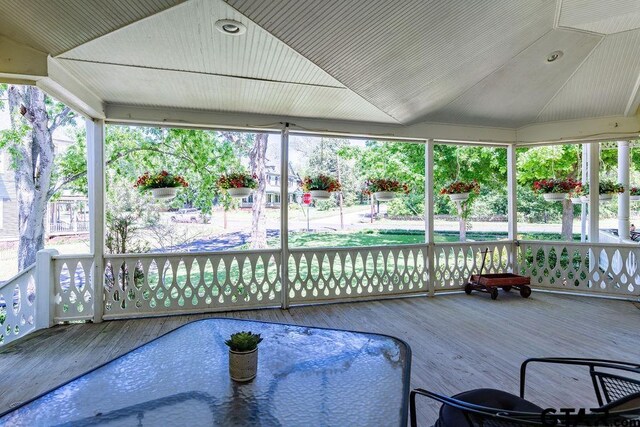 sunroom / solarium featuring plenty of natural light and vaulted ceiling