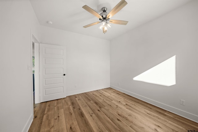 unfurnished room featuring ceiling fan, light hardwood / wood-style flooring, and a skylight