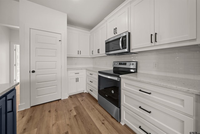 kitchen featuring stainless steel appliances, light hardwood / wood-style floors, white cabinetry, and light stone countertops