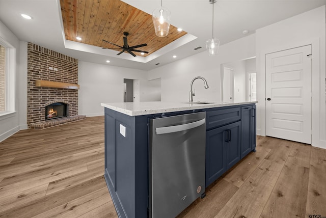 kitchen featuring decorative light fixtures, stainless steel dishwasher, wooden ceiling, a tray ceiling, and a center island with sink