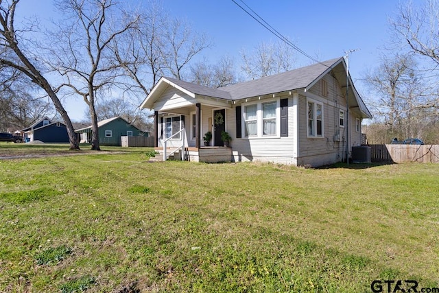 view of front of house with covered porch, a front lawn, and central AC unit