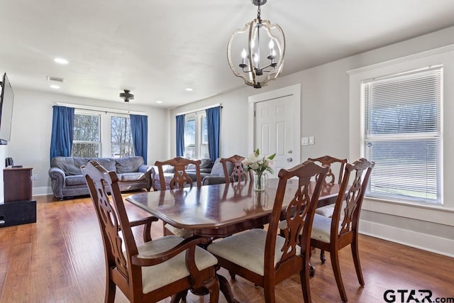 dining space featuring dark wood-type flooring and a chandelier