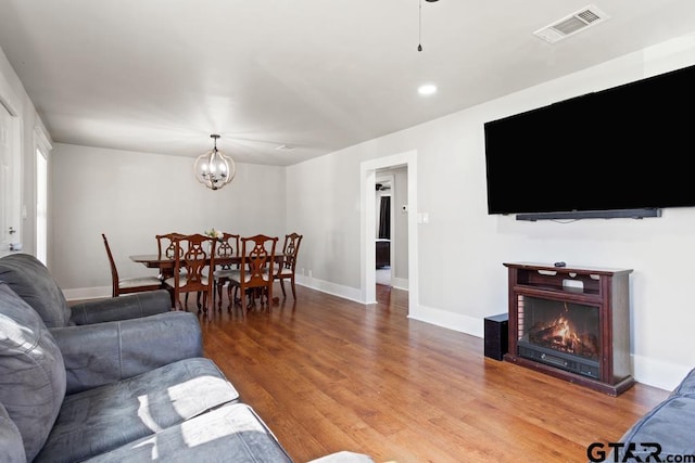 living room featuring hardwood / wood-style floors and an inviting chandelier