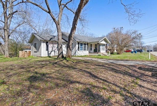 ranch-style home featuring a porch and a front yard