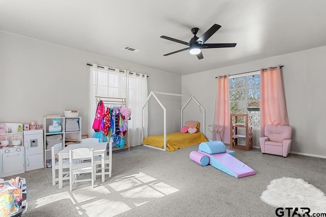 playroom with ceiling fan, light carpet, and a healthy amount of sunlight