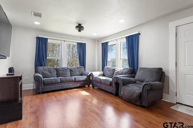 living room featuring hardwood / wood-style floors and ceiling fan