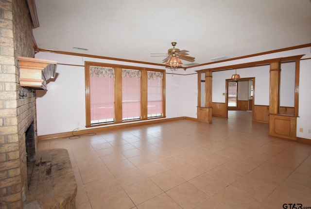 unfurnished living room with crown molding, a brick fireplace, and ceiling fan