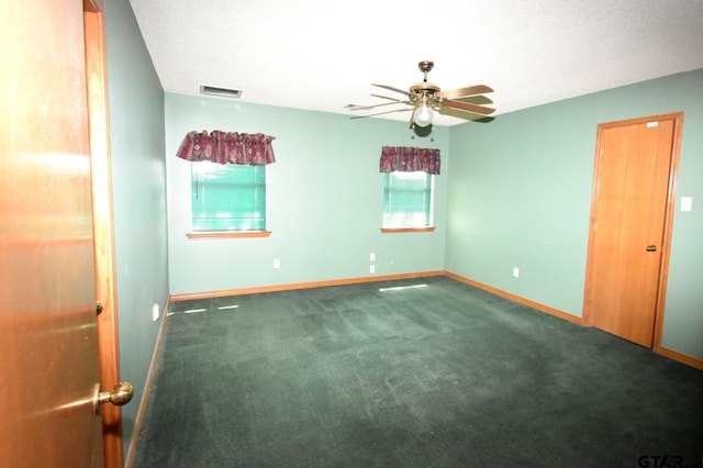 empty room featuring ceiling fan, carpet, and a textured ceiling