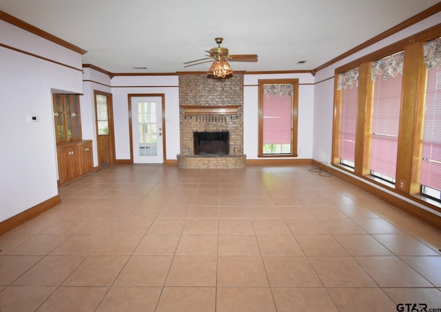 unfurnished living room with light tile patterned floors, ornamental molding, a brick fireplace, and ceiling fan