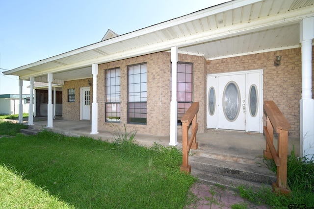 view of exterior entry with covered porch