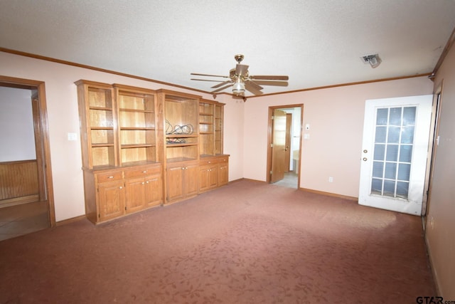 unfurnished living room with ceiling fan, carpet floors, ornamental molding, and a textured ceiling