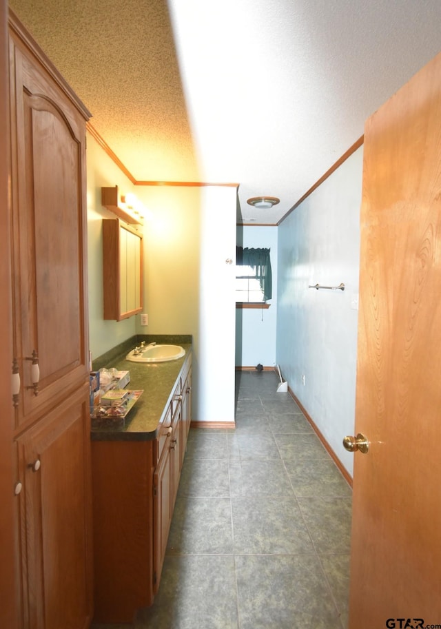 bathroom with crown molding, vanity, and a textured ceiling