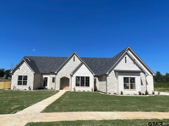 french provincial home featuring a front yard