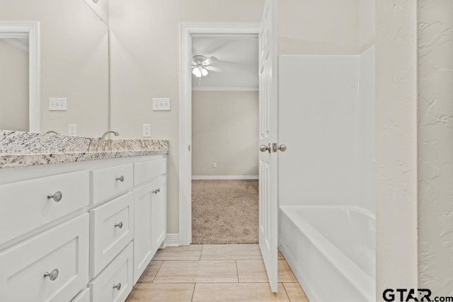 bathroom with ceiling fan, ornamental molding, vanity, and a bath