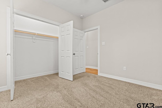 unfurnished bedroom featuring carpet flooring and a closet