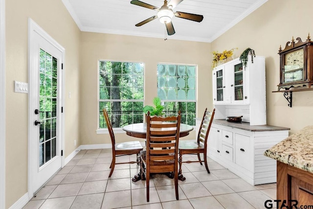 dining room featuring crown molding, light tile patterned flooring, and a wealth of natural light