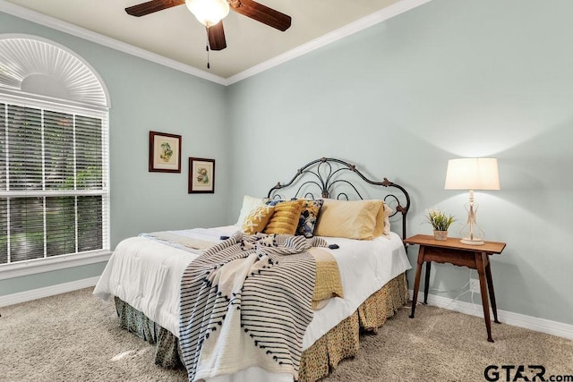 carpeted bedroom with baseboards, ornamental molding, and a ceiling fan