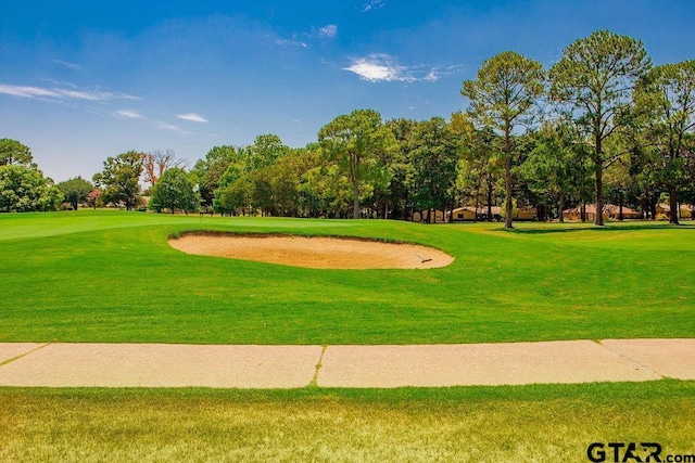 surrounding community with a yard and golf course view