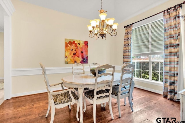 dining room featuring baseboards, wood finished floors, and a notable chandelier